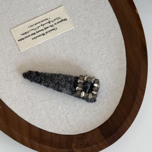 Detailed view of vintage plush hair clip with square crystal rhinestones on a display tray