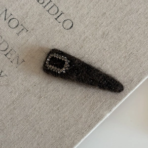 Macro shot of luxury wool hair clip featuring sparkling rectangular diamond encrusting