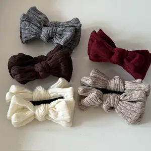 Détails de pinces à cheveux avec nœuds tricotés en cinq tons automnaux sur fond blanc