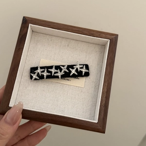 Détail de la pince à cheveux en velours avec étoiles en strass dans un coffret en bois