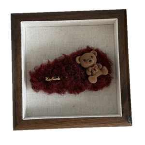 Handmade burgundy plush teddy bear art in dark brown wood frame with golden tag