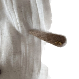 Vintage brown knitted hair clip with a gold 'Hand Made' label for a stylish daily look