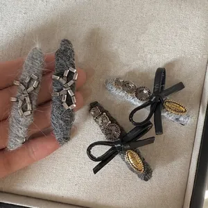 Luxe rhinestone bow hair clips set with grey plush texture and golden metal accents