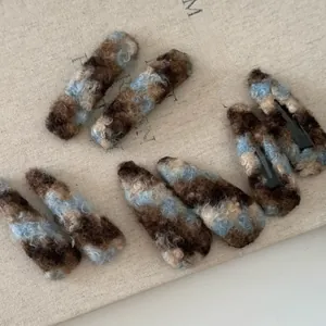 Détail de la texture pelucheuse et du clip en métal du lot de 9 barrettes colorées