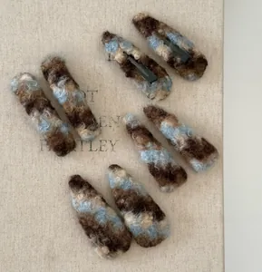 Gros plan de pinces à cheveux en peluche avec texture de laine marbrée bleue