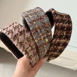 Detail of wide tweed headbands featuring golden Love metal plate and houndstooth texture
