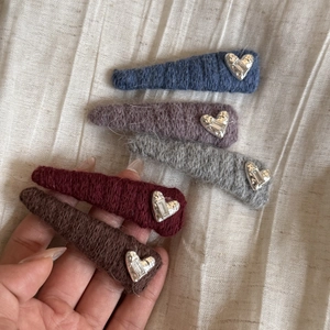Detailed shot of knitted hair clips in five colors with silver heart and crystal accents