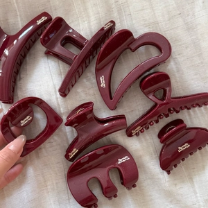 Lot de pinces à cheveux rouge foncé pailletées de différentes tailles sur lin beige