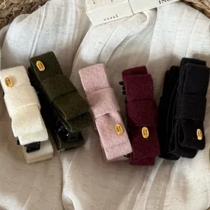 Dettaglio di fermagli per capelli in feltro fatti a mano in vari colori con tag d'oro
