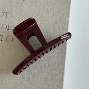 Détail de la pince à cheveux bordeaux brillante avec texte argenté Barrette La France