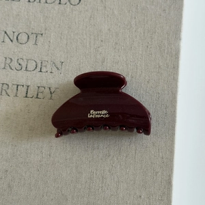 Détail macro d'une pince à cheveux rouge brillant avec inscription dorée Barrette La France