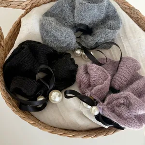 Three knit mohair scrunchies in black grey and purple with satin bows and pearl charms