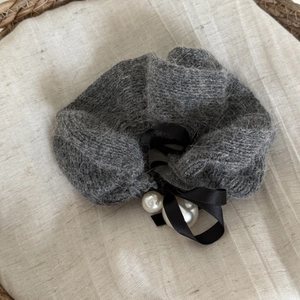 Elegant dark grey knit plush scrunchie featuring a black satin bow and white faux pearls