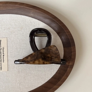 Detailed view of a handmade acetate shark clip with tortoise shell pattern and gold lettering
