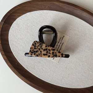 Close-up of tortoise shell triangle detail on black acetate hair claw clip