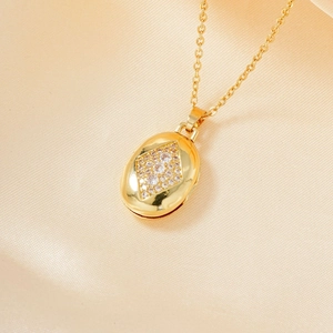 Elegante collar con relicario ovalado dorado y diseño de diamantes sobre seda champán