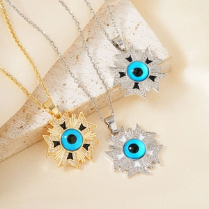 Three gold and silver evil eye sunburst pendant necklaces on cream silk and stone