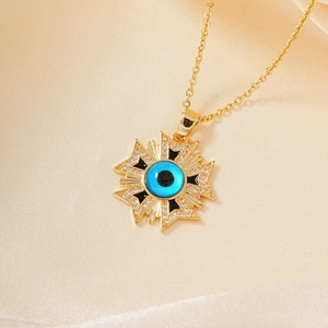 Golden eye medallion necklace featuring blue evil eye charm and sparkling white zircons