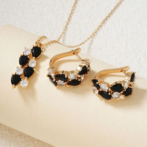Detailansicht des goldenen Schmucksets mit schwarz-weißen Zirkonia-Anhängern
