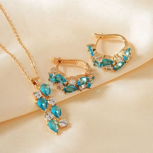 Detail eines vergoldeten Schmucksets mit birnenförmigen blauen Zirkonia auf Champagner-Satin
