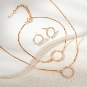 Golden jewelry set with necklace bracelet and earrings featuring CZ inlaid open circles