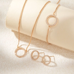 Elegant gold-tone jewelry set featuring circular pendants with sparkling micro-pave crystals