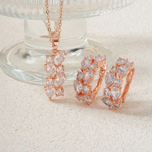Schmuckset in Roségold mit Tropfen-Zirkonia-Anhängerkette und Creolen auf Weiß