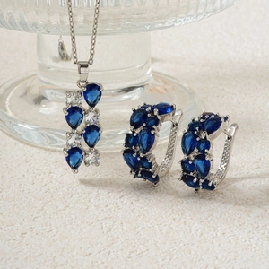 Makroaufnahme von Silberschmuck-Set mit birnenförmigen blauen Steinen und Kristallen