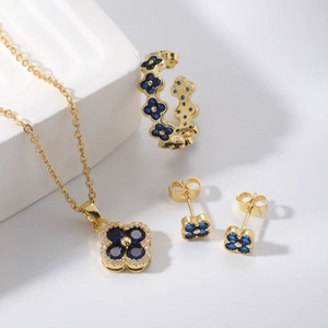 Goldschmuck-Set mit vierblättrigem Kleeblatt und blauen Steinen aus Kette und Ohrringen