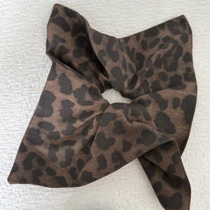 Detailed texture of leopard print chiffon scrunchie on white fabric background