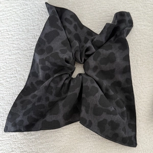 Detail view of retro leopard print scrunchie with long ribbons in dark grey fabric