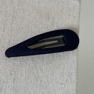 Detailed macro shot of dark blue twill fabric texture on a vintage French BB hair clip