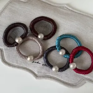 Détail de 5 chouchous rétro en soie avec d'élégants accents de perles argentées