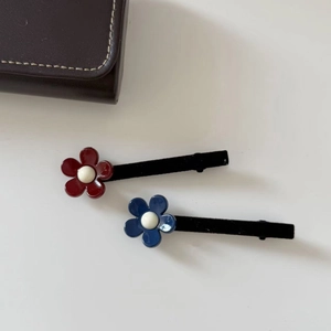 Barrettes fleurs rouge et bleu en résine avec pinces en velours noir sur blanc
