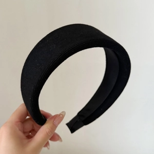 Detail of black wide knitted headband showing the ribbed fabric texture and volume