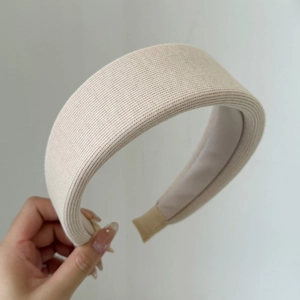 Detail shot of beige knitted wide sponge headband with soft textured fabric finish