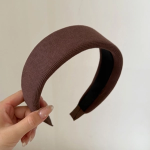 Detail view of coffee brown knitted headband with soft ribbed fabric and non-slip velvet lining
