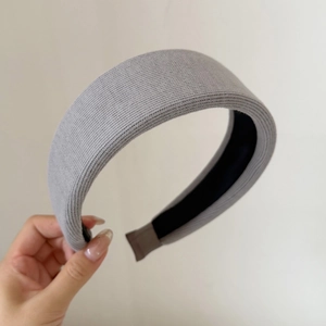 Macro shot of gray knitted padded headband with ribbed texture and brown edge covers