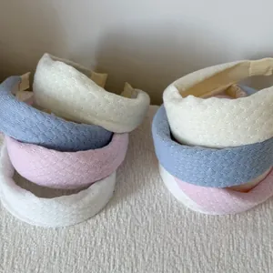 Detailed view of honeycomb knit headbands in white, pink, and blue with thick padding