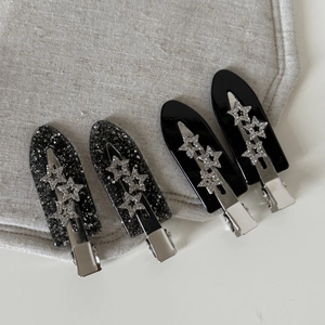 Set of four black glitter and glossy acetate star hair clips with silver metal base