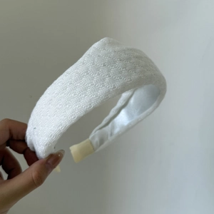 Detail showing white thick knitted headband with breathable texture and soft inner lining