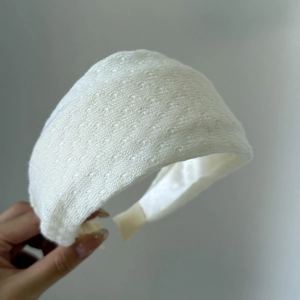 Retro style wide white knit headband featuring an intricate hollow-out floral texture
