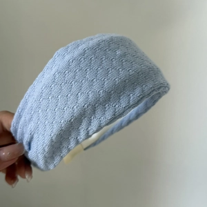 Macro shot of the light blue knitted wide headband with detailed woven texture