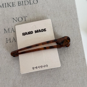Elegant tortoiseshell seamless hair clip with leopard print on a handmade display card