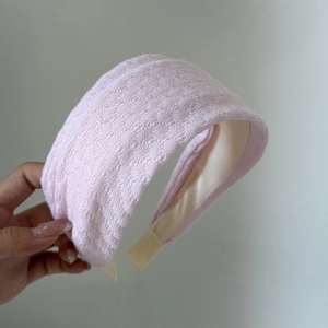 Close-up of pink wide knit headband showing texture and elastic band for comfort