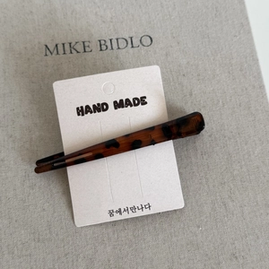 Handmade tortoise leopard print seamless duckbill hair clip on a minimalist display card