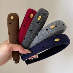 Détail de serre-têtes épais en feutre de laine avec coeurs noirs et boucles dorées Love