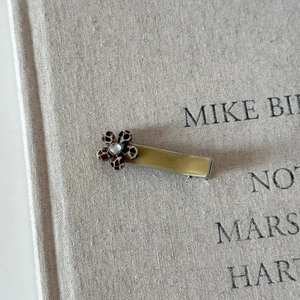 Detail of leopard print flower hair clip with a sparkling rhinestone on soft fabric