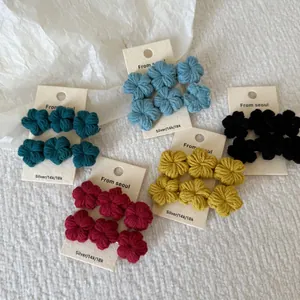 Detailed set of five pairs of small colorful crochet flower hair clips on display cards