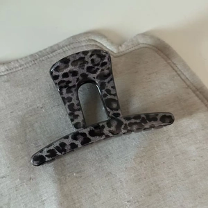 French grey leopard print hair claw clip in acetate for elegant updos on plain fabric